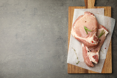 Fresh raw beef cut with spices on grey table, top view. Space for text