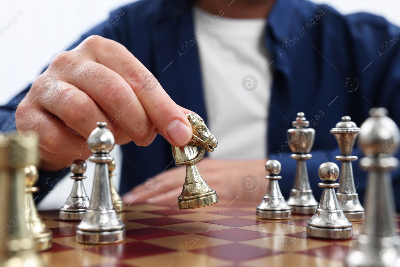 Photo of Man moving knight on chessboard, closeup view