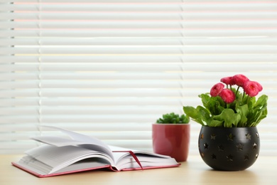 Photo of Window with blinds, beautiful potted plants and notebook on sill, space for text