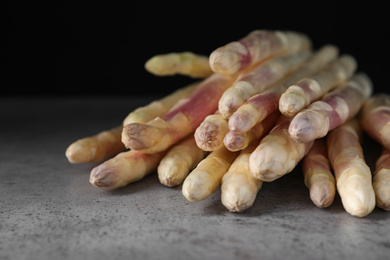 Pile of fresh white asparagus on grey table, closeup