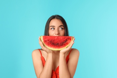 Photo of Beautiful young woman posing with watermelon on color background