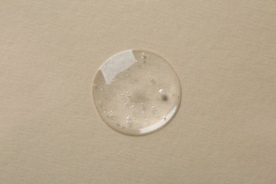 Photo of Sample of cosmetic serum on beige background, top view