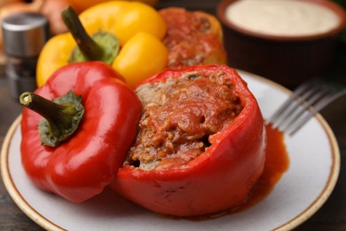 Photo of Delicious stuffed bell peppers served on wooden table, closeup