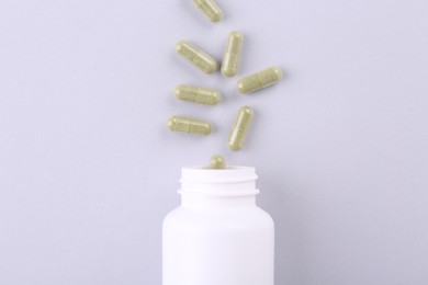 Jar with vitamin capsules on white background, top view