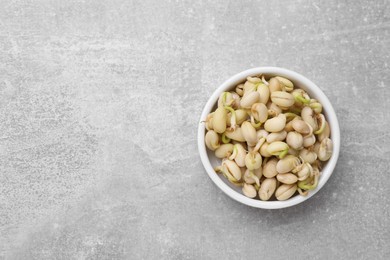 Sprouted kidney beans in bowl on light grey table, top view. Space for text