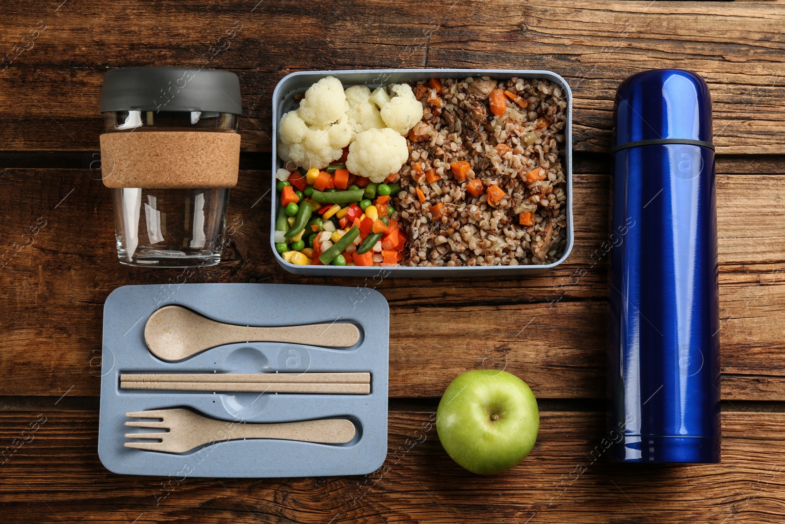 Photo of Flat lay composition with thermos and lunch box on wooden background