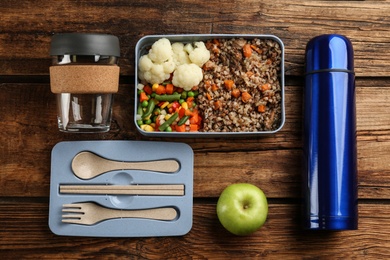 Photo of Flat lay composition with thermos and lunch box on wooden background