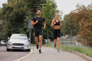 Photo of Healthy lifestyle. Happy sporty couple running outdoors