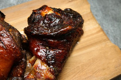 Photo of Delicious roasted pork foreshanks on wooden board, closeup