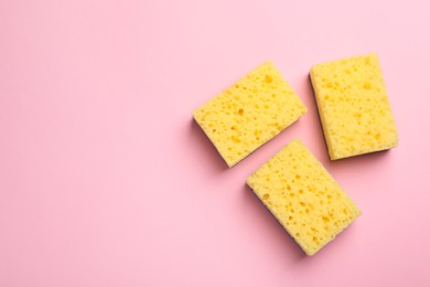 Photo of New sponges on pink background, flat lay. Space for text