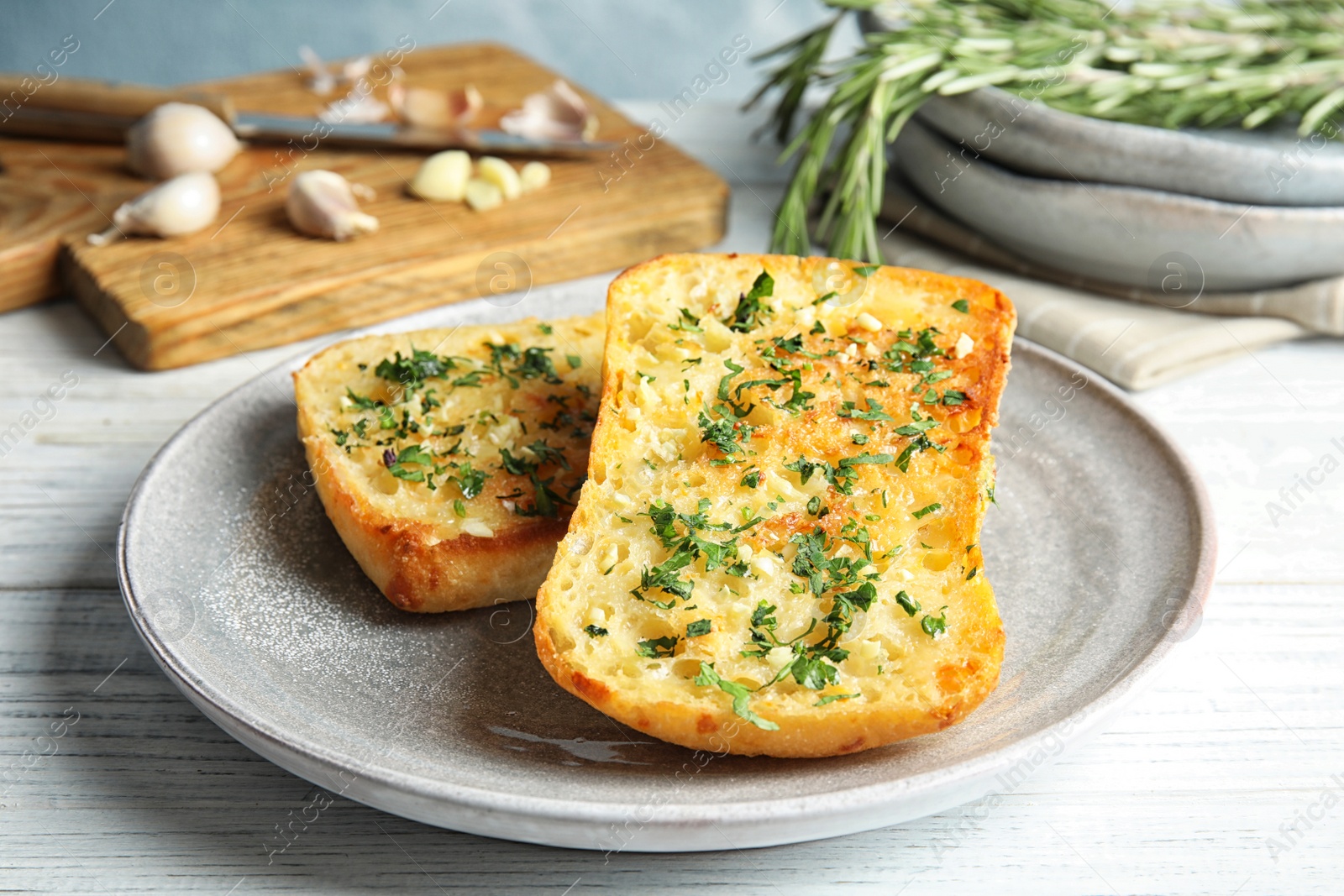 Photo of Plate with delicious homemade garlic bread on table