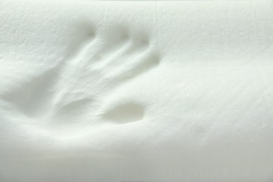 Photo of Handprint on white memory foam pillow, closeup