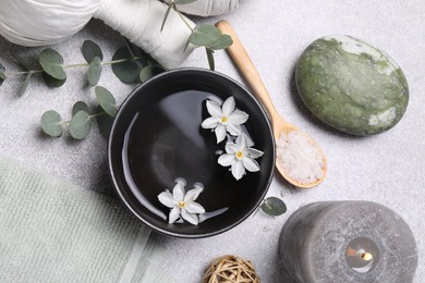 Photo of Flat lay composition with herbal massage bags, spa products and flowers on light grey table