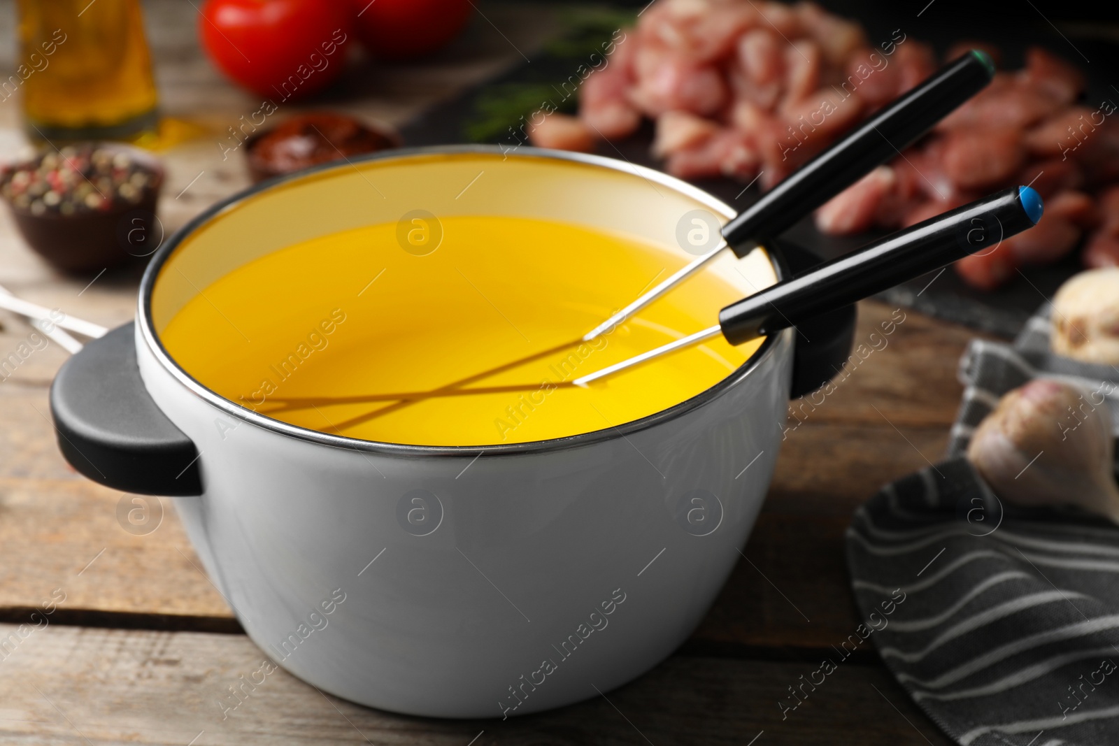 Photo of Pot with hot oil for meat fondue on table