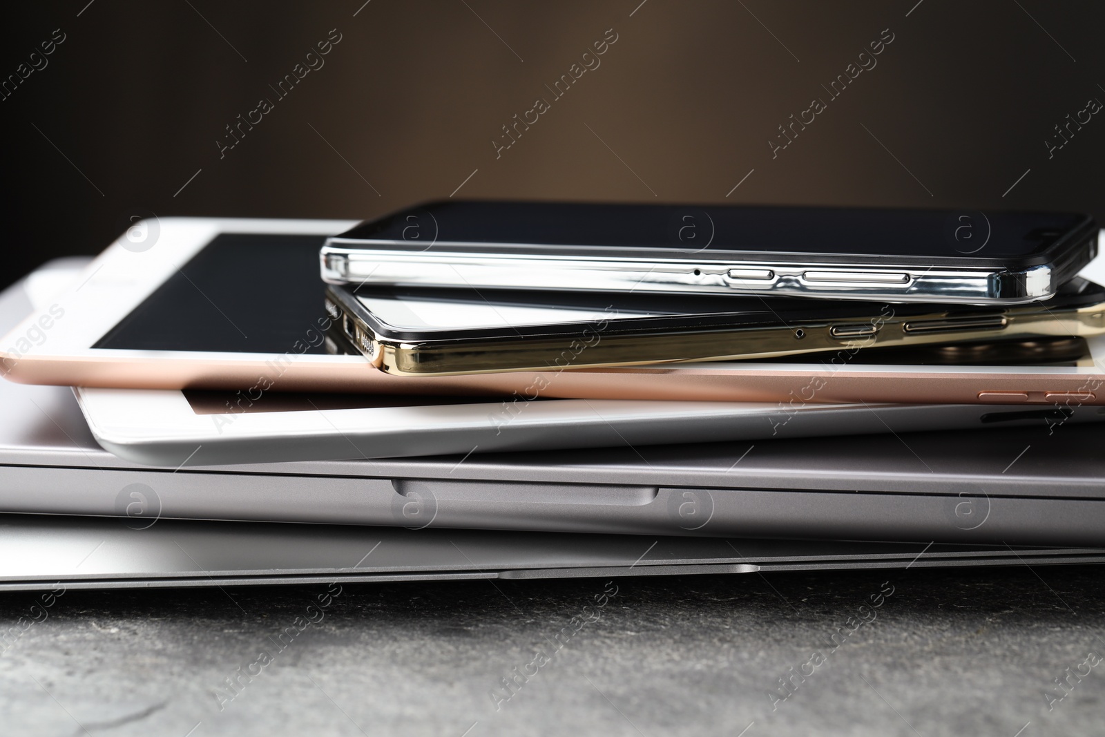 Photo of Stack of electronic devices on grey table, closeup