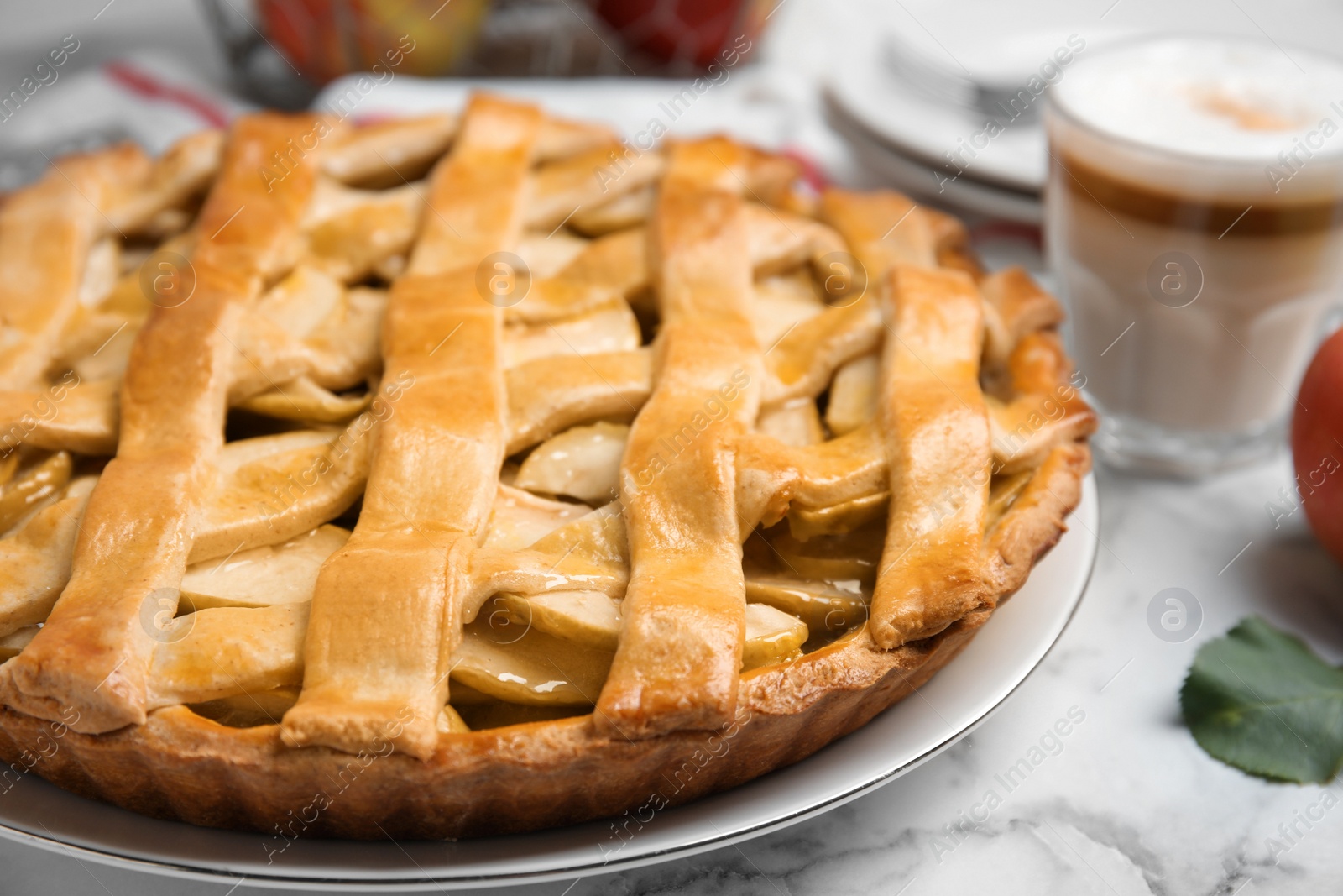 Photo of Delicious traditional apple pie on white marble table, closeup