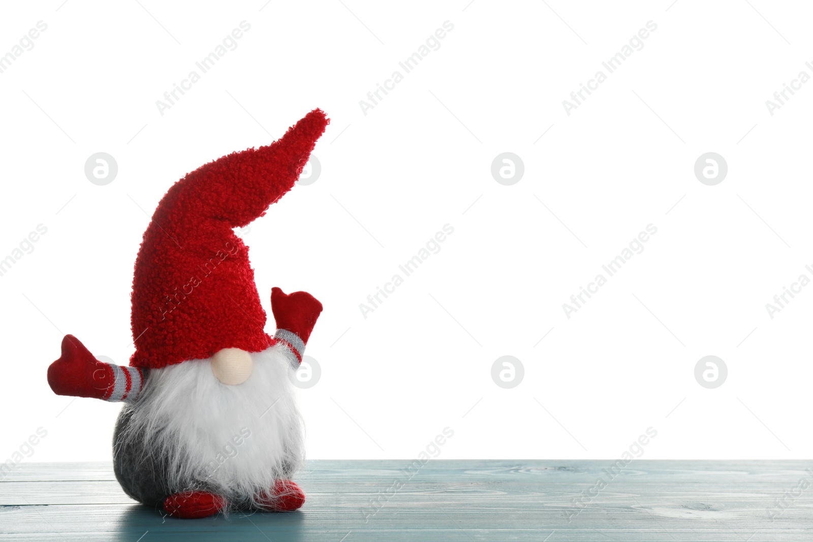 Photo of Funny Christmas gnome on turquoise wooden table against white background. Space for text