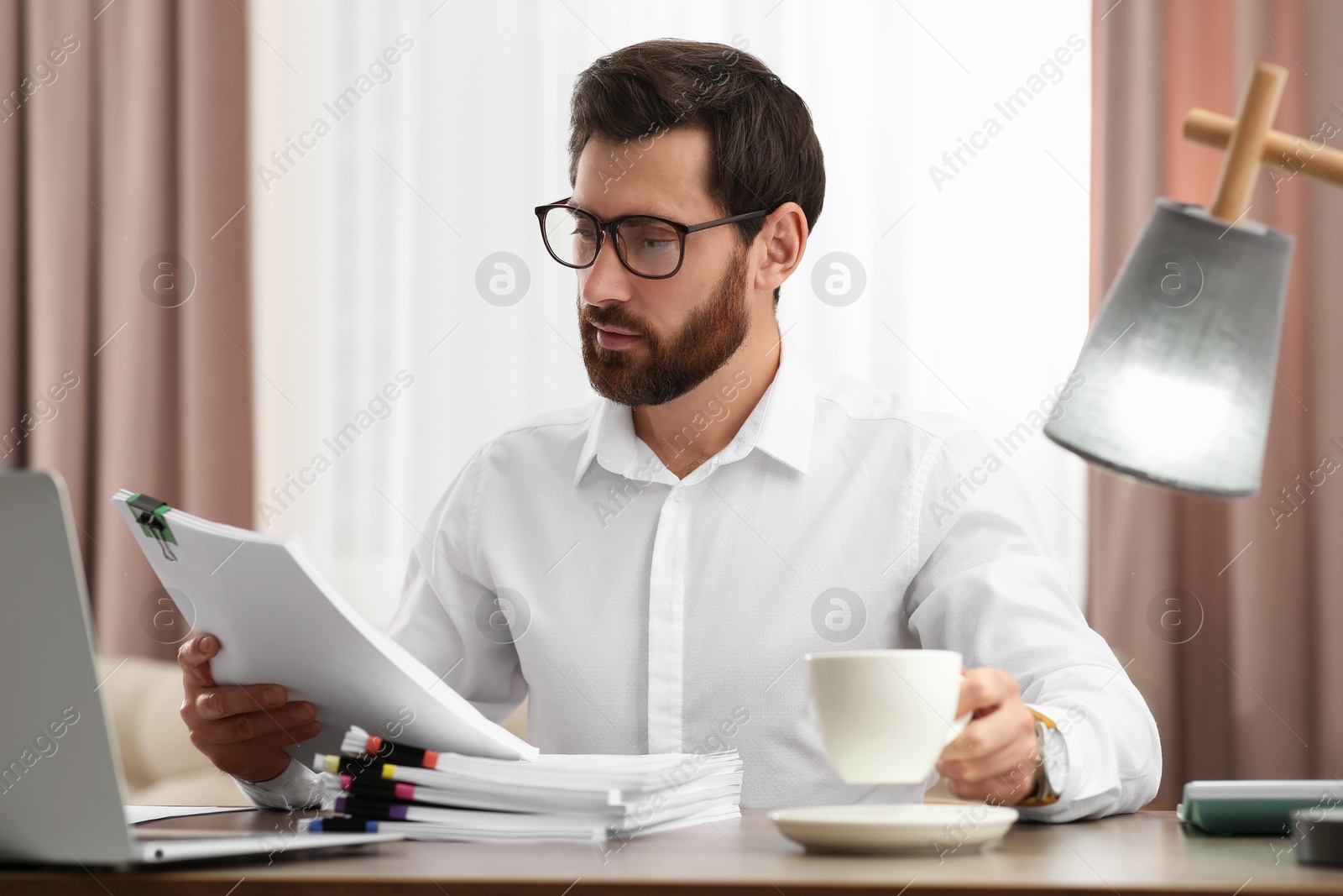 Photo of Businessman working with documents at wooden table in office