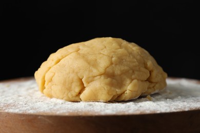 Photo of Making shortcrust pastry. Raw dough and flour on board, closeup