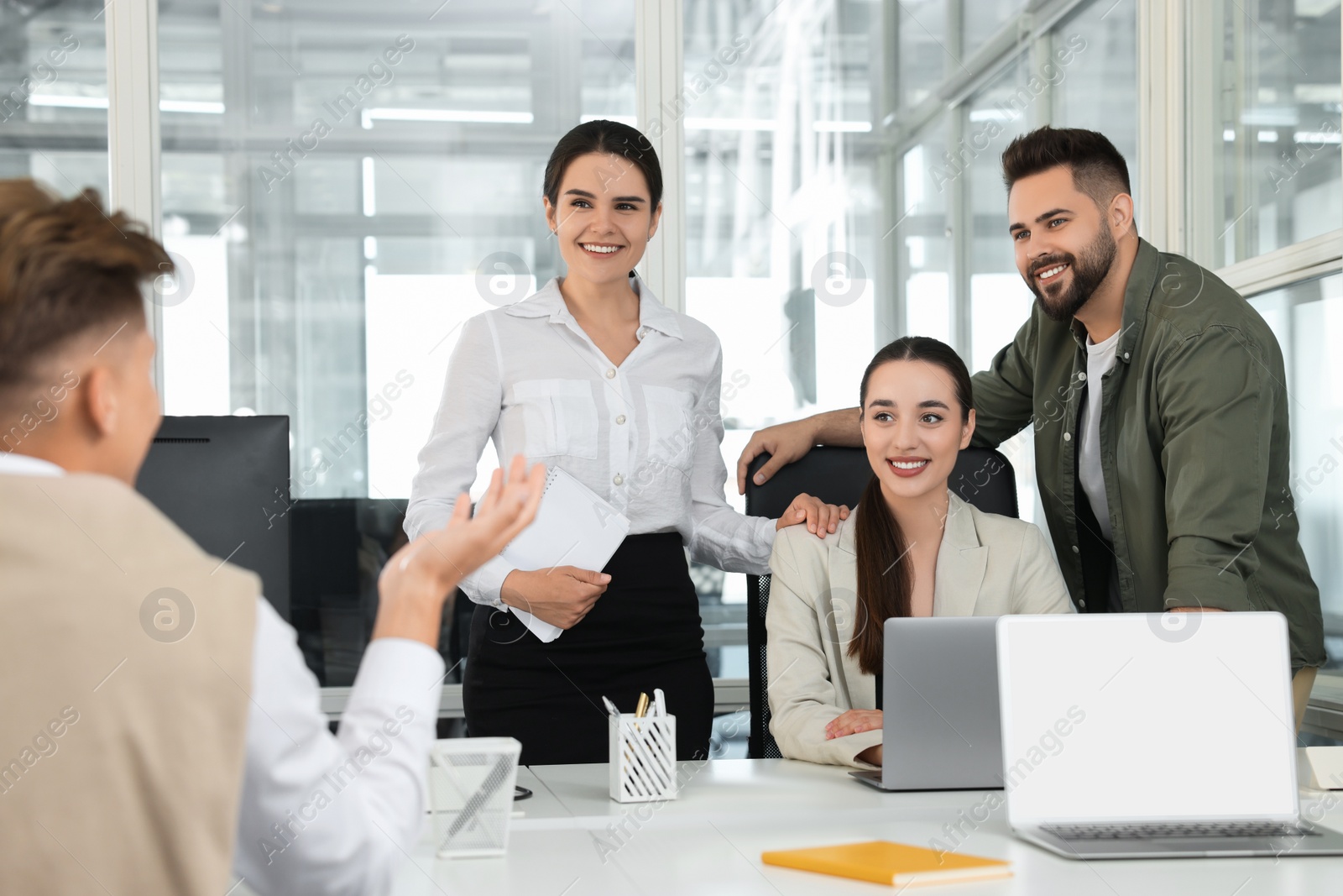 Photo of Colleagues working together in open plan office