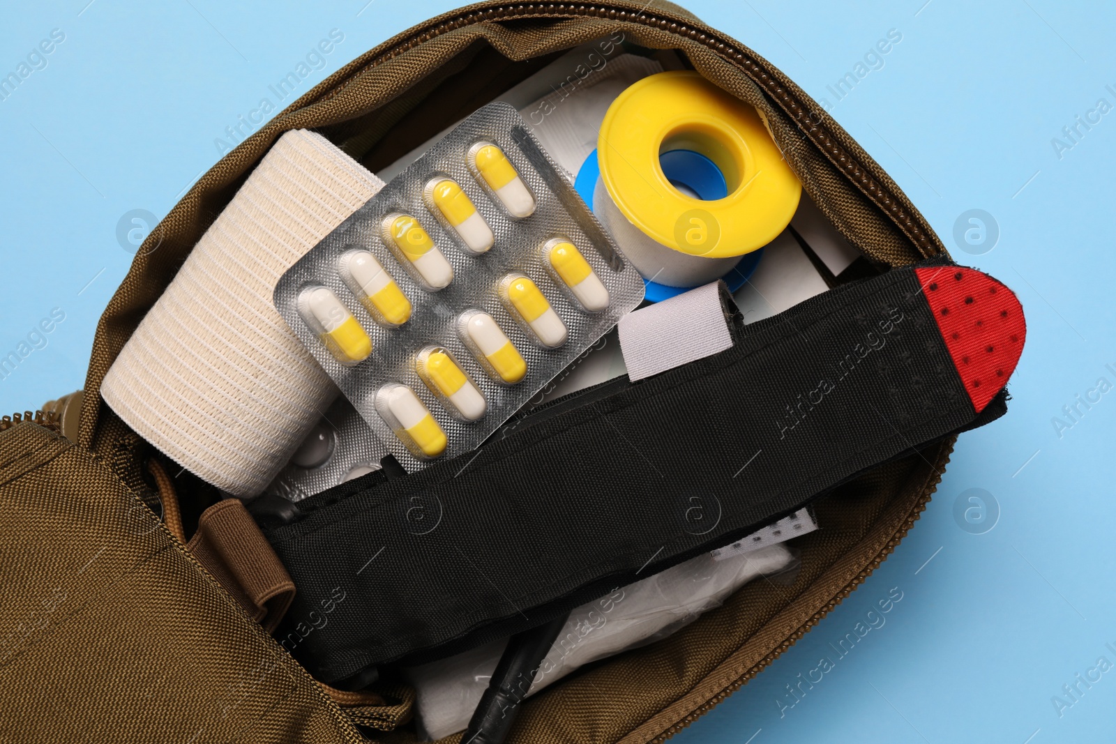 Photo of Military first aid kit on light blue background, top view