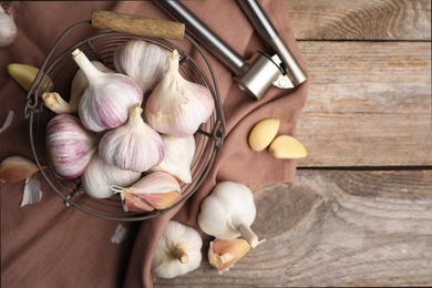 Fresh organic garlic on wooden table, flat lay. Space for text