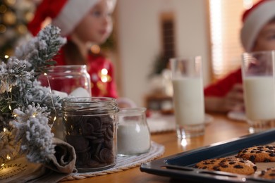 Photo of Cute little children with delicious Christmas cookies at home, focus on pastry