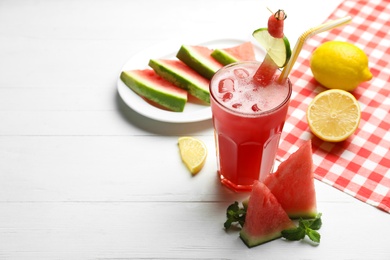 Photo of Delicious fresh watermelon drink on white wooden table. Space for text