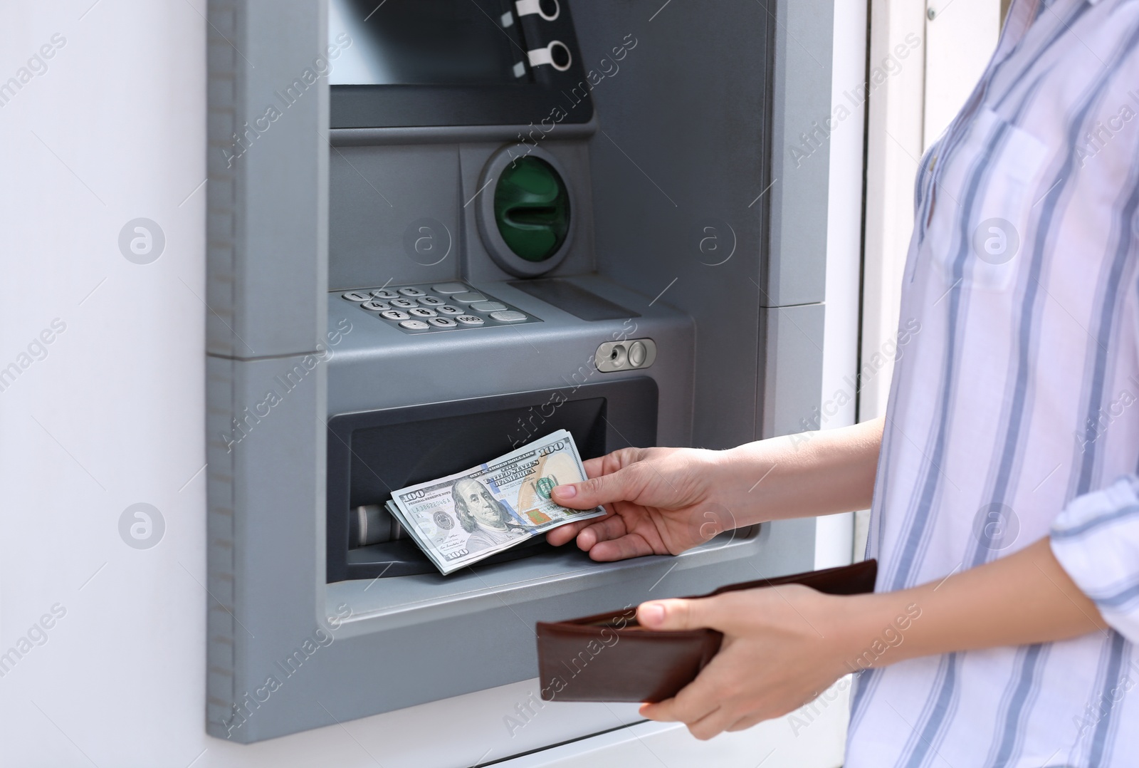 Photo of Woman taking money from cash machine outdoors, closeup