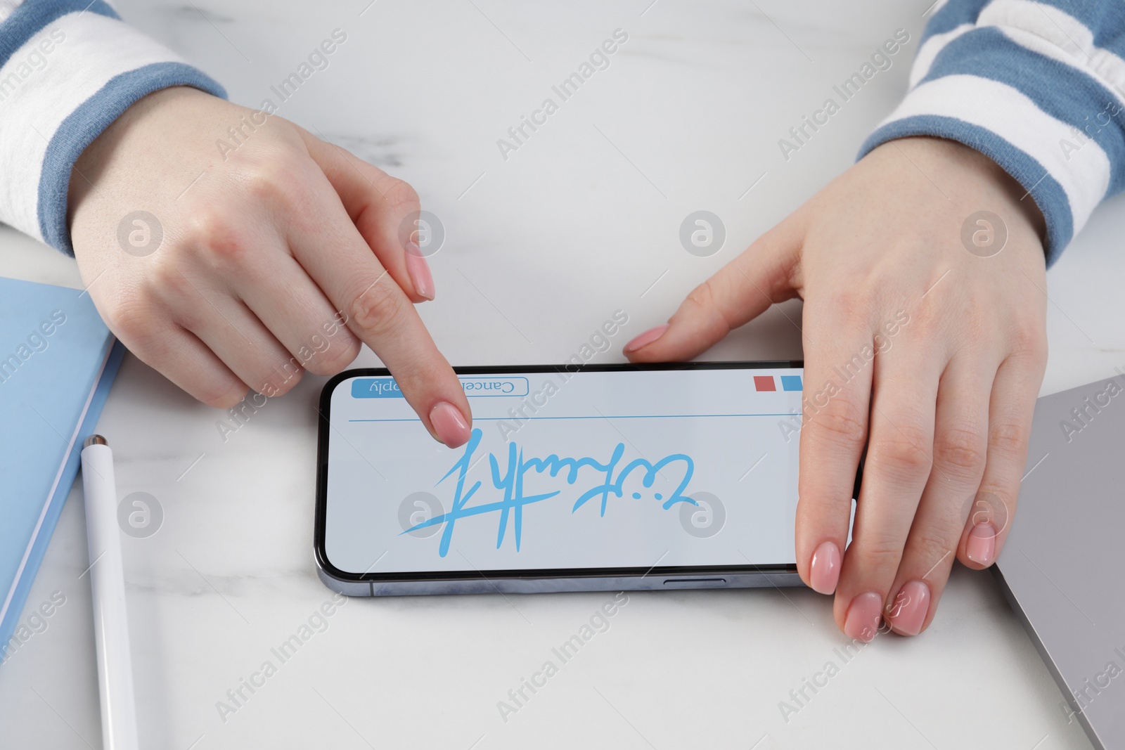 Image of Electronic signature. Woman using mobile phone at white table, closeup