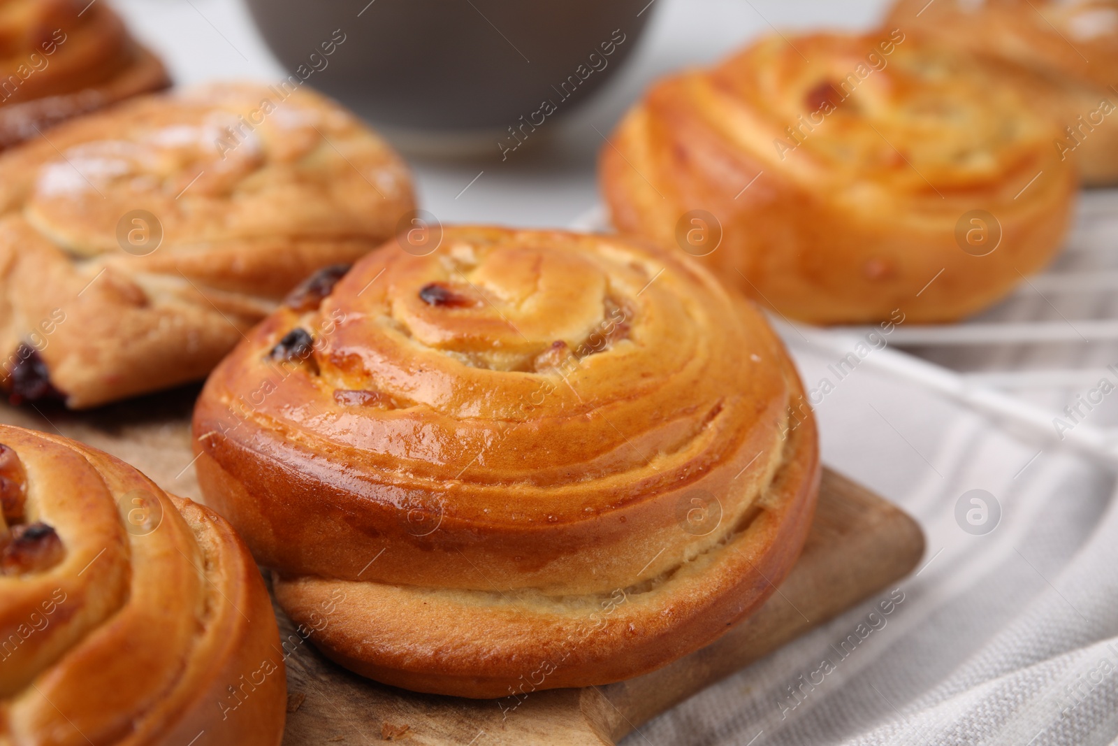 Photo of Delicious rolls with raisins on table, closeup. Sweet buns