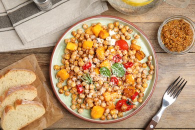 Delicious fresh chickpea salad served on wooden table, flat lay