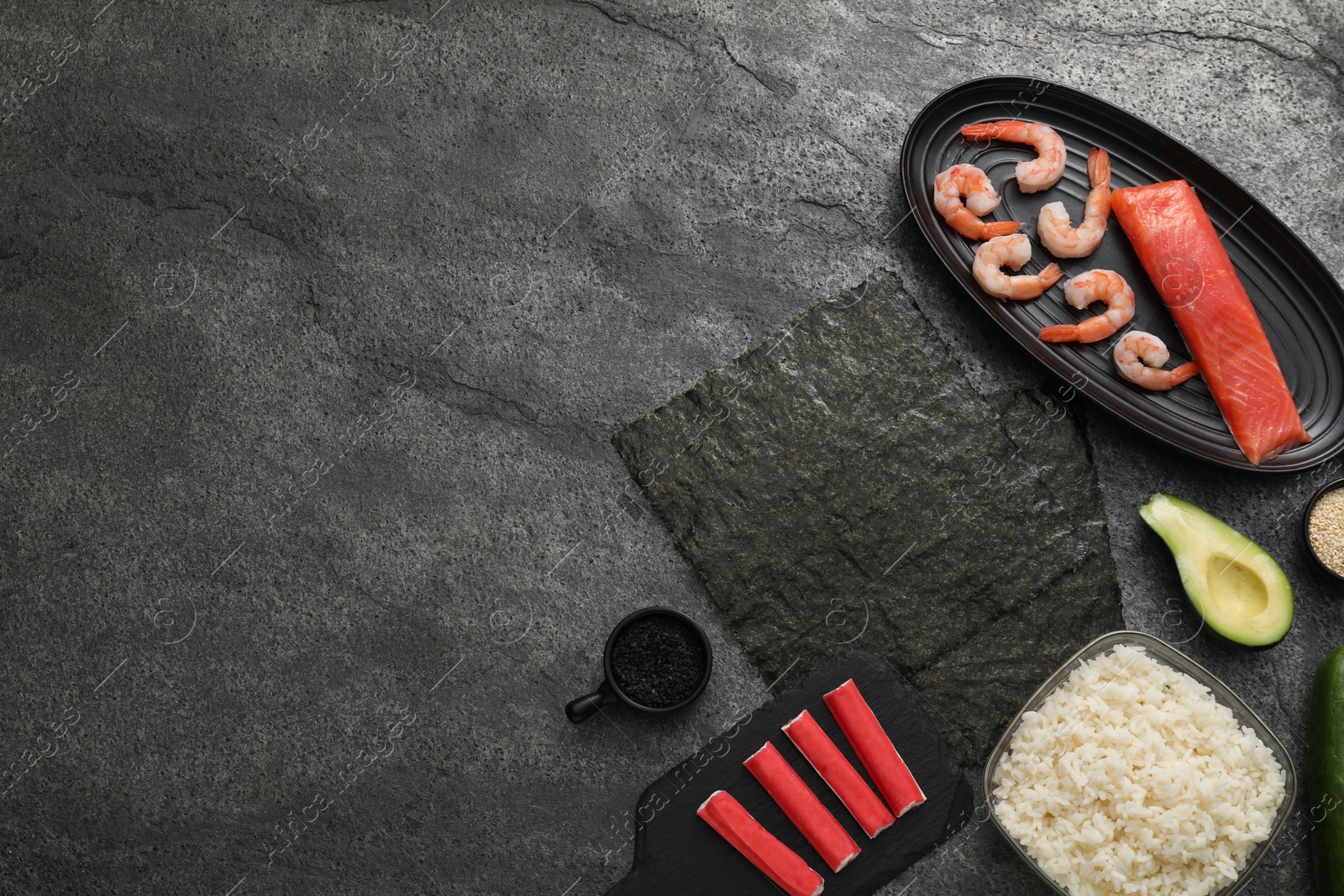 Photo of Flat lay composition with ingredients for sushi on dark textured table. Space for text