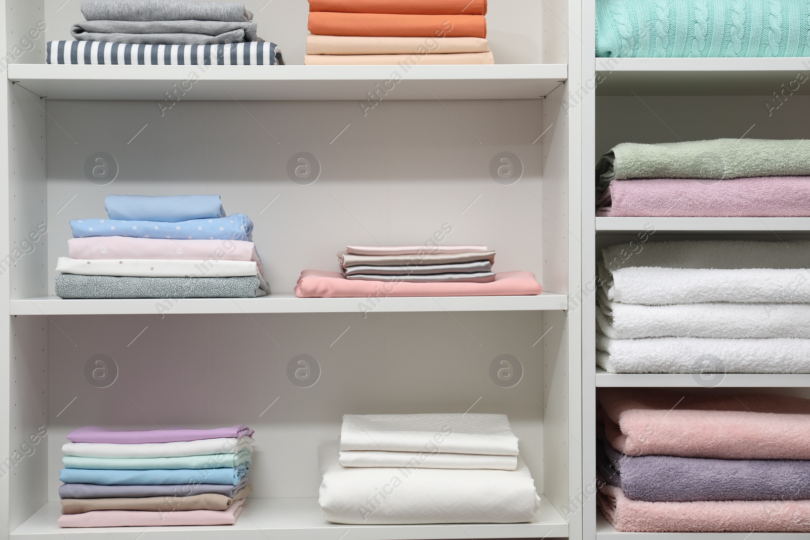 Photo of Different color linens on shelves in shop