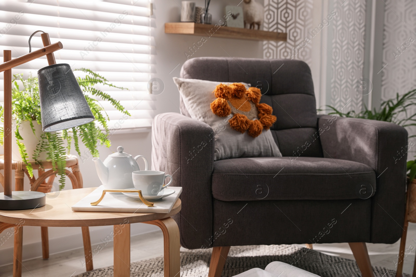 Photo of Comfortable place for rest with armchair near window in room