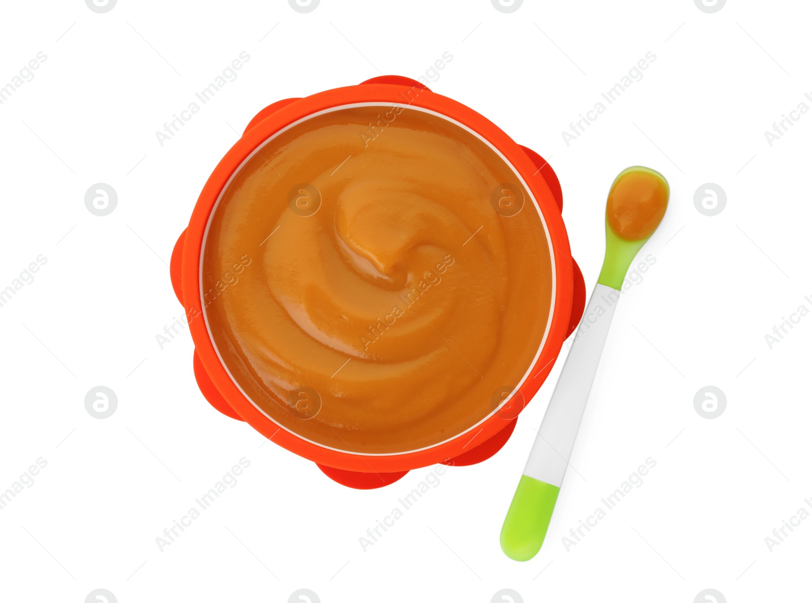 Photo of Bowl and spoon with tasty pureed baby food isolated on white, top view