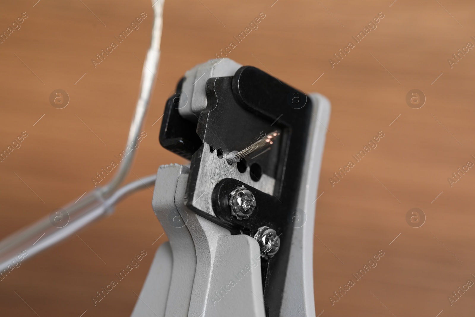 Photo of Cutters and stripped wire on light brown background, closeup