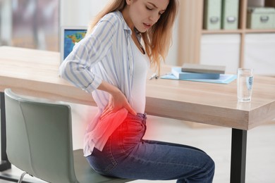 Image of Woman suffering from back pain in office. Symptom of bad posture