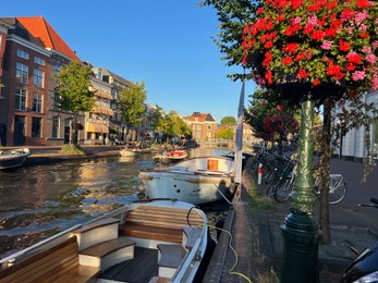 Leiden, Netherlands - August 1, 2022: Picturesque view of city canal with moored boats and beautiful buildings