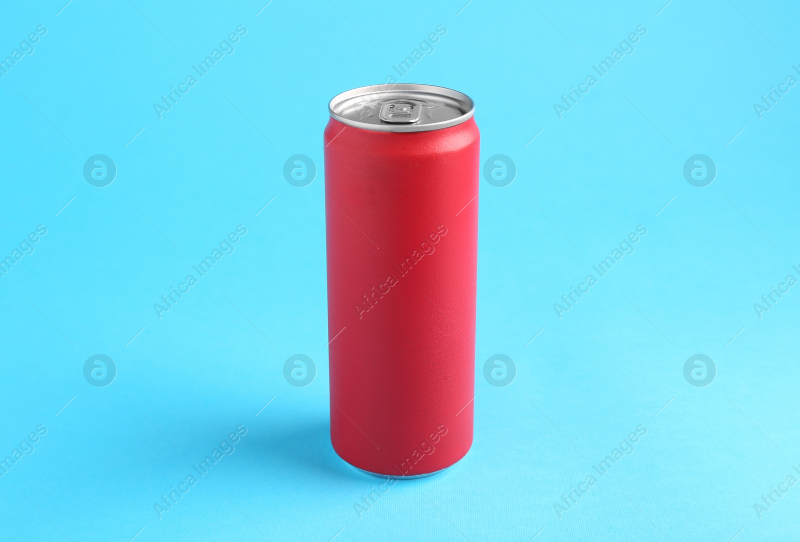 Photo of Energy drink in red can on light blue background