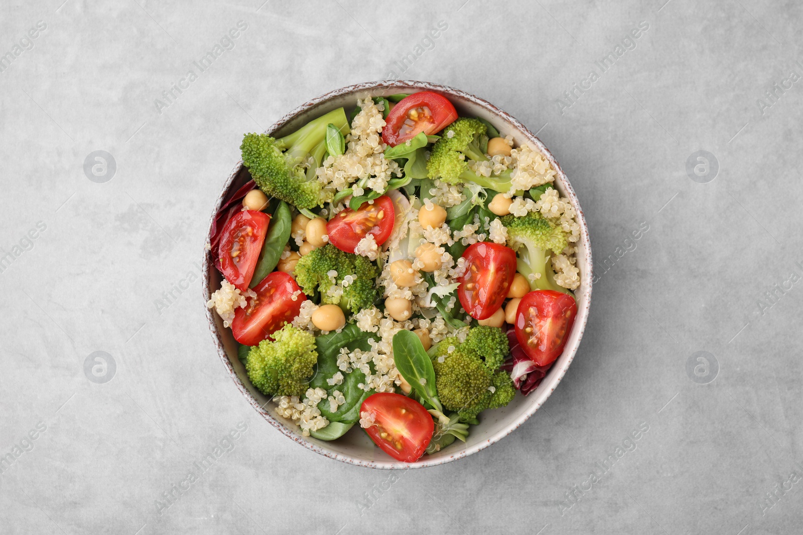 Photo of Healthy meal. Tasty salad with quinoa, chickpeas and vegetables on grey table, top view