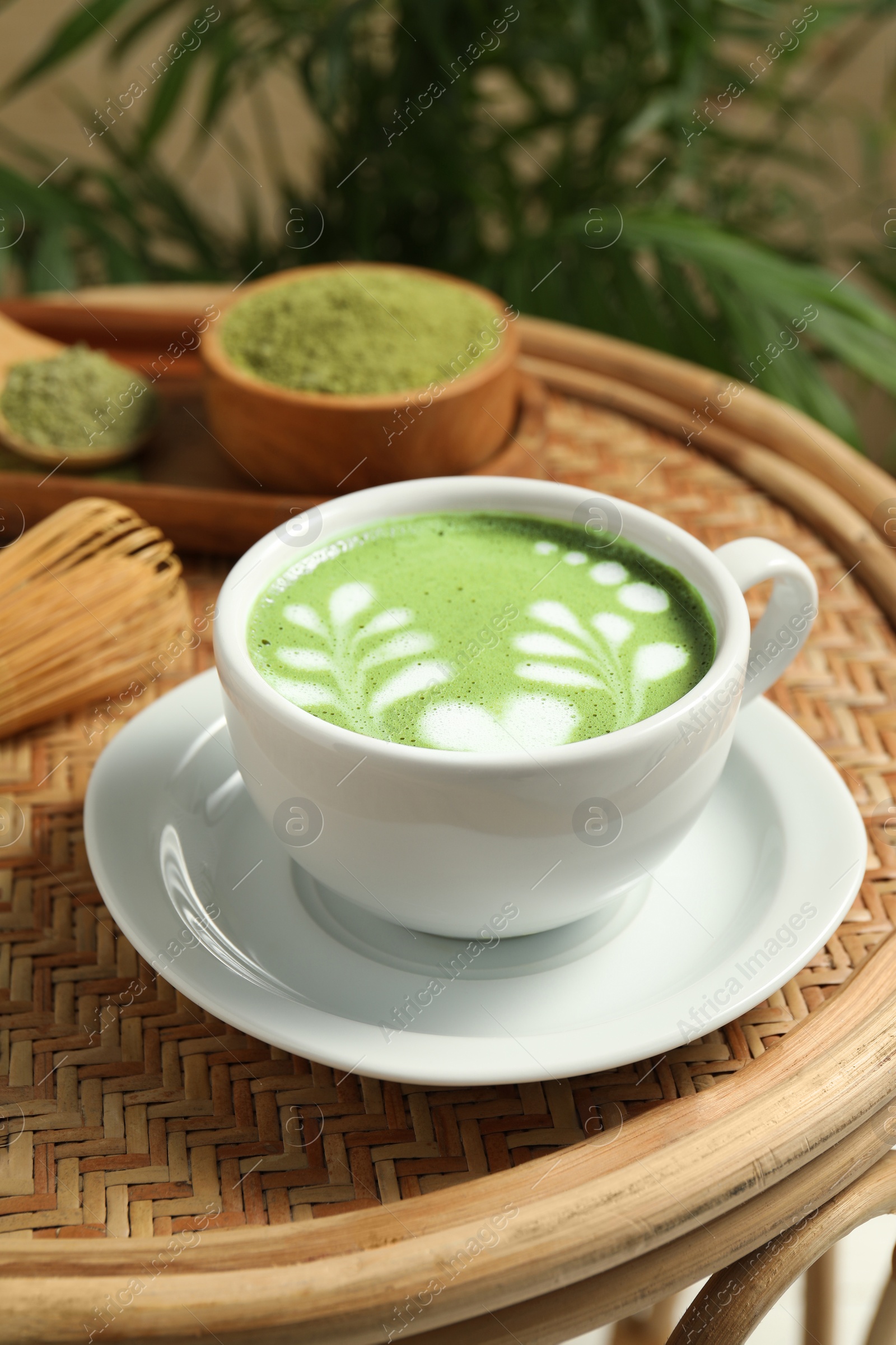 Photo of Delicious matcha latte in cup on table