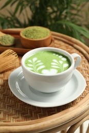 Delicious matcha latte in cup on table