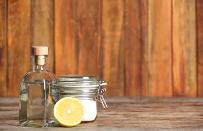 Photo of Composition with vinegar, lemon and baking soda on table. Space for text