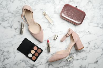 Photo of Flat lay composition with stylish shoes, cosmetics and woman's bag on white marble table