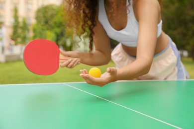African-American woman playing ping pong outdoors, closeup