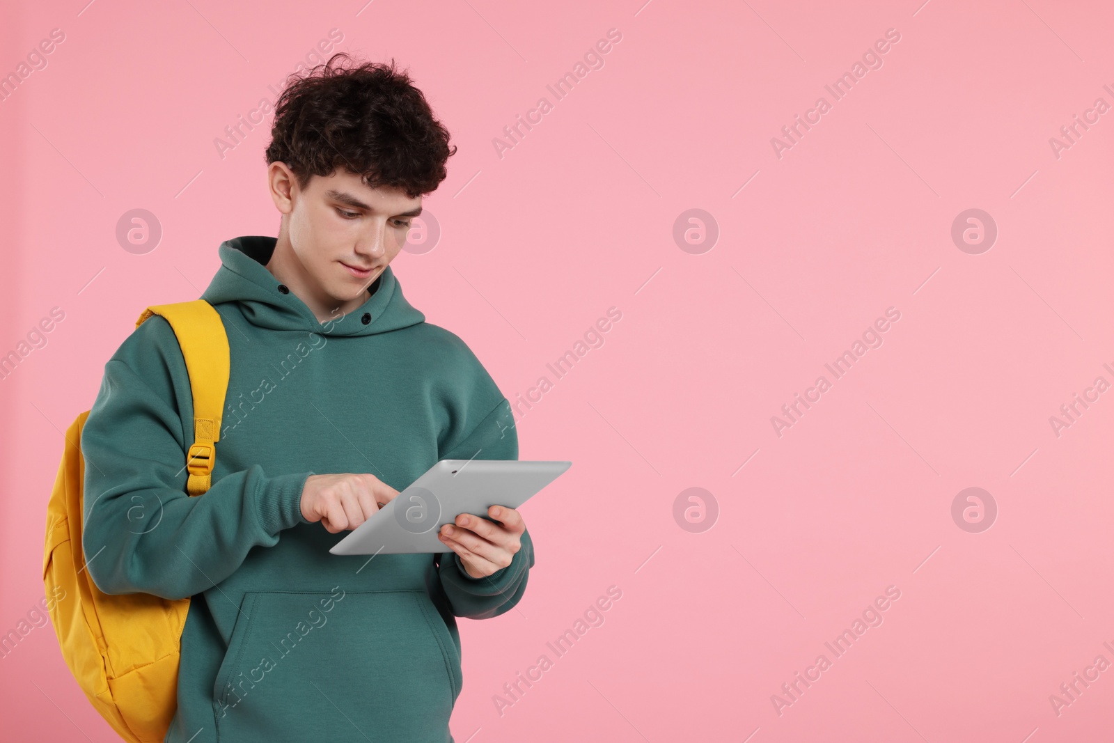 Photo of Portrait of student with backpack and tablet on pink background. Space for text