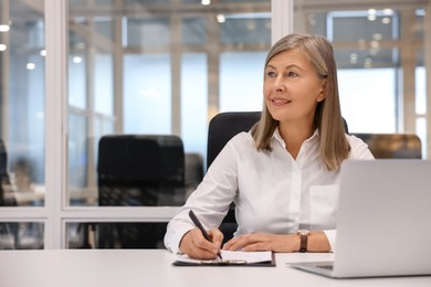 Photo of Smiling woman with clipboard and laptop working in office, space for text. Lawyer, businesswoman, accountant or manager