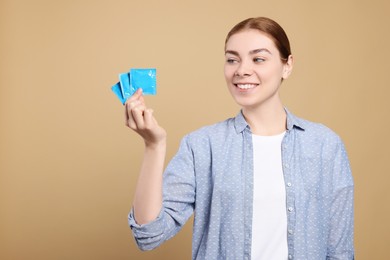 Photo of Woman holding condoms on beige background. Safe sex