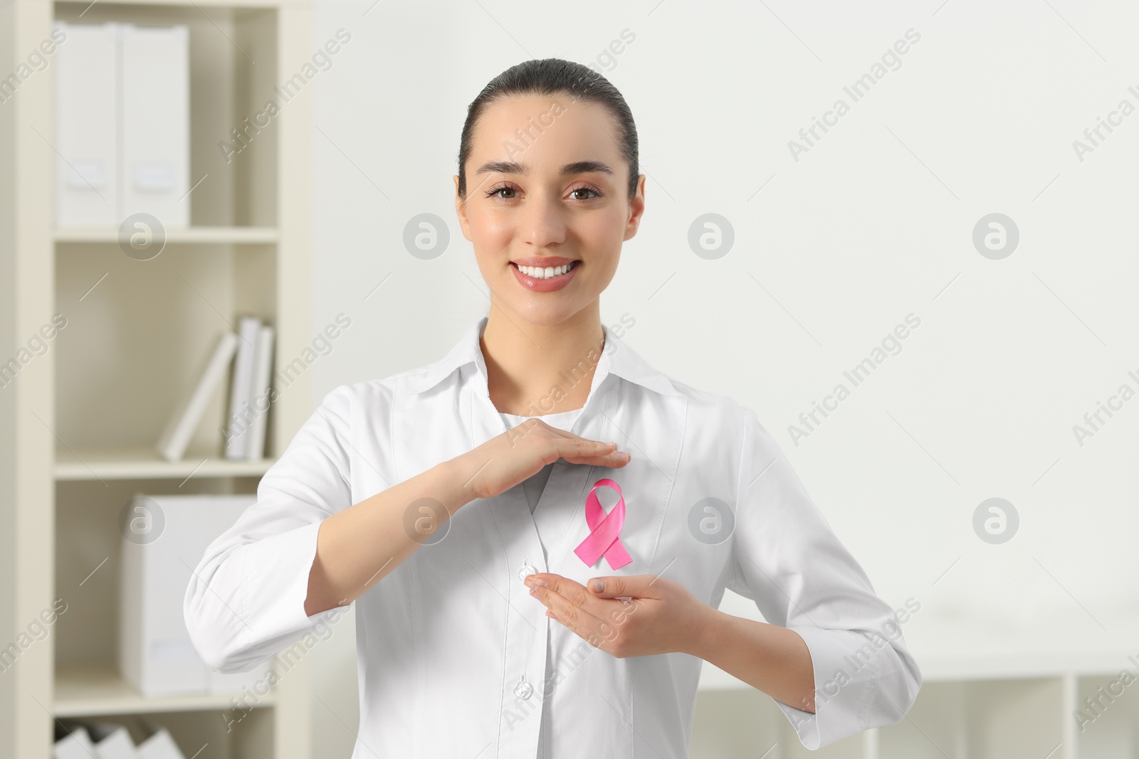 Photo of Mammologist with pink ribbon in hospital. Breast cancer awareness